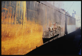 Durban, 1987. Maintenance work on side of ship in Durban Harbour.