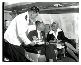 
SAA Boeing 707 interior. Cabin crew serving passengers.
