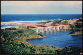 Natal, circa 1971. SAR Class 5E1 on suburban train crossing bridge over a river mouth on Natal So...