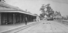 King William's Town, 1895. Station buildings with man on platform and crane truck in the distance...