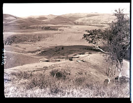 Transkei, 1932. Rolling hills with huts in the distance.