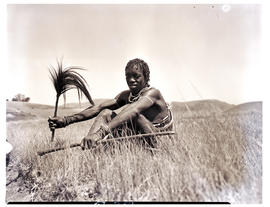 Zululand, 1950. Zulu man sititng in grass.