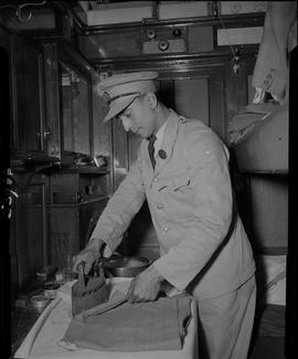 
SAR bedding attendant ironing his uniform.
