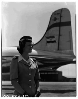 September 1952. Miss Badenhorst, air hostess, at tail of SAA Douglas DC-4 Skymaster.