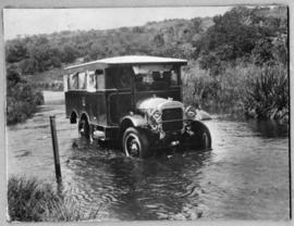 Circa 1926. Thornycroft three-axle bus fording river in flood.
