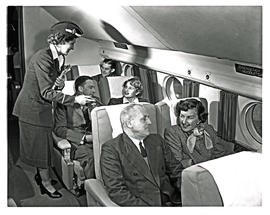 
SAA Lockheed Constellation interior. Hostess handing out literature to passengers.
