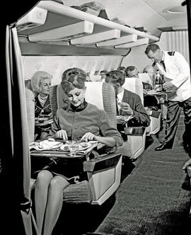 
SAA Boeing 707 interior. Enjoying a meal. Steward.
