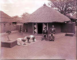 "Louis Trichardt district, 1960. Bavenda Chieftain on chair before hut with three women knee...