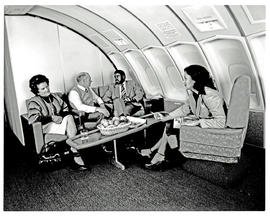 
SAA Boeing 747 interior. Passengers in lounge area. Smoking.
