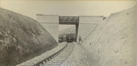 Railway wagons under small bridge over cutting on new railway line.