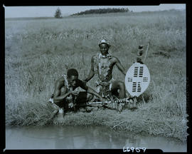 Zululand, 1957. Two Zulu men drinking water at river.