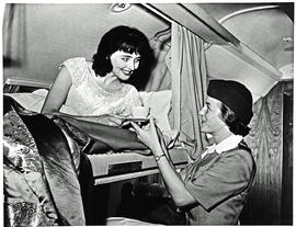 
SAA Douglas DC-7B interior. Sleeper bunk, hostess serving tea.

