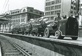 Johannesburg, 1948. SAR tractor No P010 with trailers and milk cans on station platform.