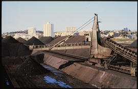 Port Elizabeth, August 1985. Manganese ore stockpiles in Port Elizabeth Harbour. [D Dannhauser]