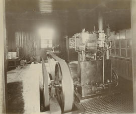 Belt-driven mechanical equipment, equipment dated 1901., omside building of corrugated iron.