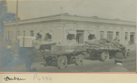 Durban. Truck with trailer with bags in front of South African Railways (SAR) building.