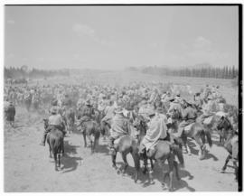 Basutoland, 12 March 1947. Mounted riders in foreground, royal cavalcade driving off in the backg...