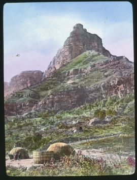 Large mountain with traditional huts in the foreground.