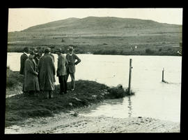 Group of men at flooded river.