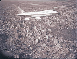Johannesburg, 1976. SAA Boeing 747SP ZS-SPA 'Matroosberg' in flight over central business district.
