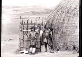 Zululand, 1933. Two Zulu warriors next to hut.
