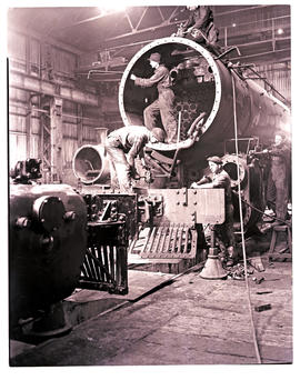 
Steam locomotive being overhauled in workshop.
