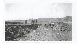 Men digging trench next to temporary trolley line.