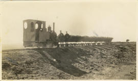 Orenstein & Koppel locomotive with goods wagons on embankment on an unknown civil site. About...