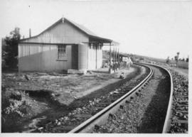 Cottage of corrugated iron next to railway line. (Lund collection)