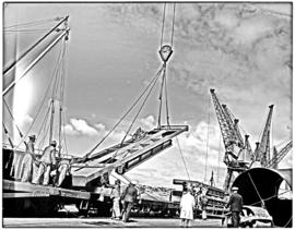 Port Elizabeth, 1948. Steel platform loaded by crane onto goods wagon in Port Elizabeth harbour.