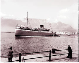Cape Town, 1952. 'Cape Town Castle' guided by tug in Table Bay harbour.