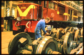 
Technician checking wheels with SAR Class 35-000 No 35-225 in the background.
