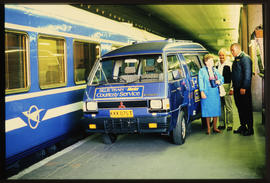 Blue Train courtesy vehicle off-loading passenger on station platform.