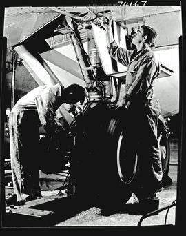 
Technicians checking Boeing 707 landing gear.
