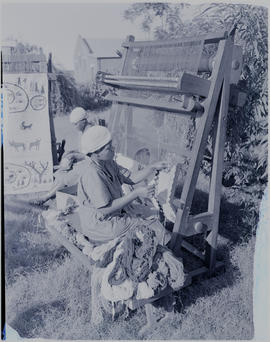 Pietermaritzburg, 1946. Women weaving carpets outdoors.