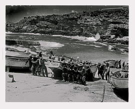 Hermanus, 1938. Hauling fishing boat out of water at harbour.