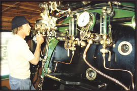 Driver inside steam loco cab.