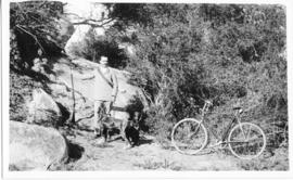 Unidentified man with two dogs and a bicycle.