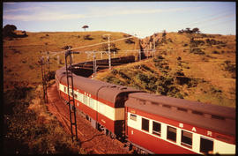 
Passenger train on winding railway line at cutting.
