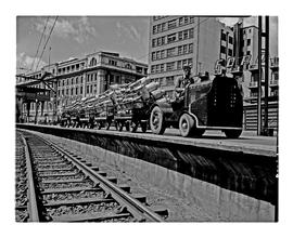 Johannesburg, 1948. SAR tractor No P010 with trailers and milk cans on station platform.