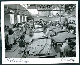 "Uitenhage, 1954. Burling and mending cloth at textile factory."
