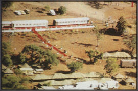 Red carpet rolled out from White Train in rural setting.