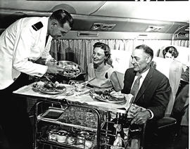 
SAA Douglas DC-7B interior, dinner being served. Steward.
