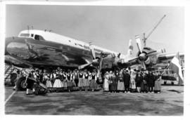 Group of dancers at SAA Douglas DC-7B ZS-DKD  'Drommedaris' with Union Jack flag. Note "Drom...