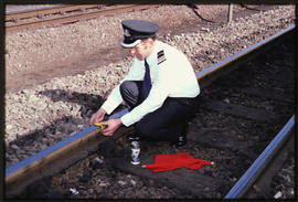 Flagman attaching detonator to rail crown prior the track occupation by track work team.