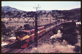 Passenger train on double track headed by two electrical locomotives.