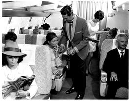 
SAA Boeing 707 interior. Cabin service. Steward and hostess. Lighting a cigarette. Smoking.
