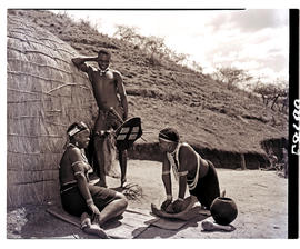 Natal, 1951. Two Zulu women and man at hut.