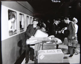 
Porter with luggage on station platform.
