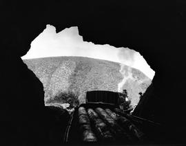 Wilderness, 1928. Freight train transportimg logs moving through a tunnel